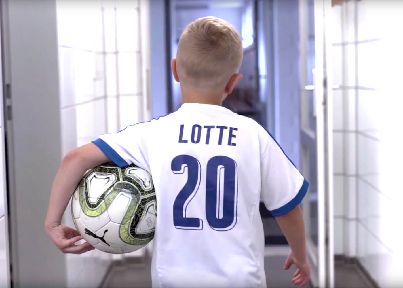 Lotte Junior-Spieler mit Trikot und Fußball unter dem Arm auf den Weg aus der Kabine